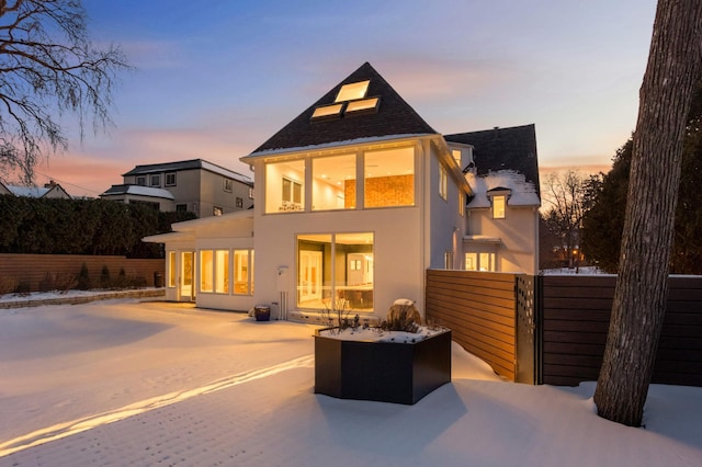 rear view of property with a patio area, fence, and stucco siding