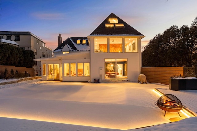 back of property at dusk featuring a patio area, fence, and stucco siding