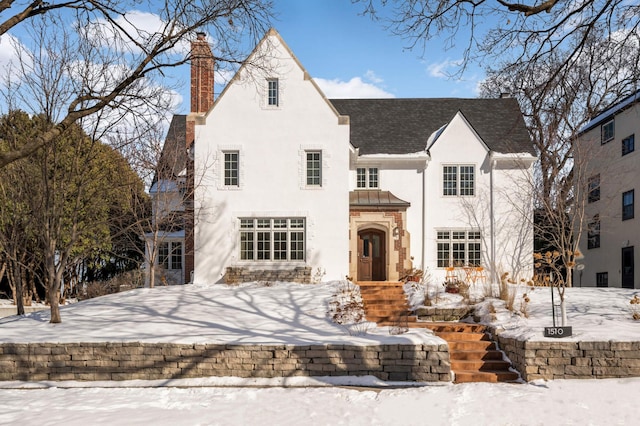 view of front of home with a chimney and stucco siding