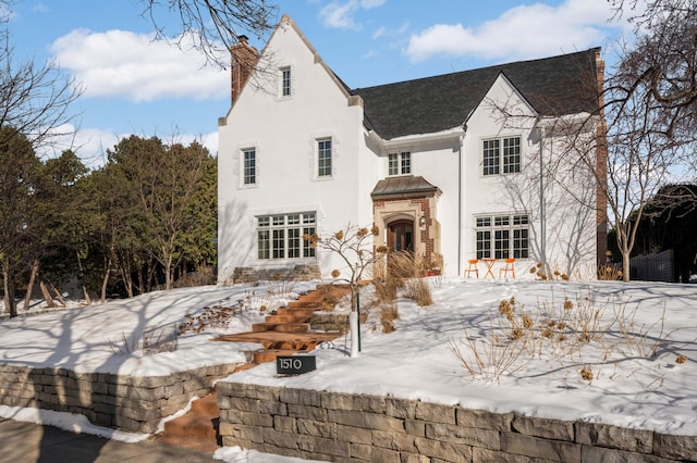 view of front of house with a chimney and stucco siding