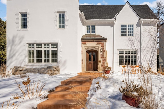 view of front of home featuring roof with shingles and stucco siding