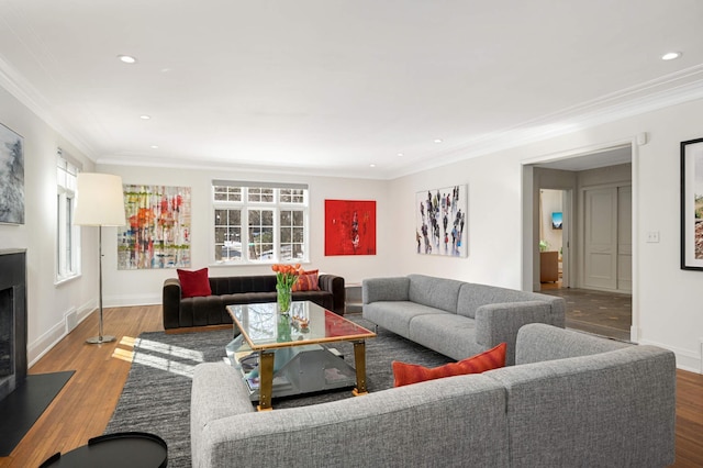 living room with a fireplace with flush hearth, crown molding, a wealth of natural light, and wood finished floors