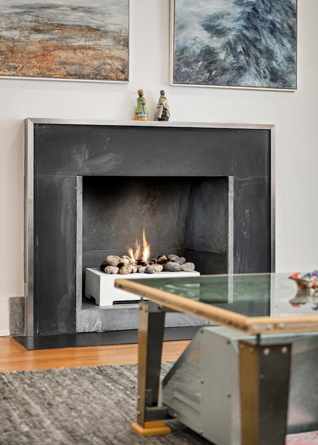 room details with a lit fireplace and wood finished floors