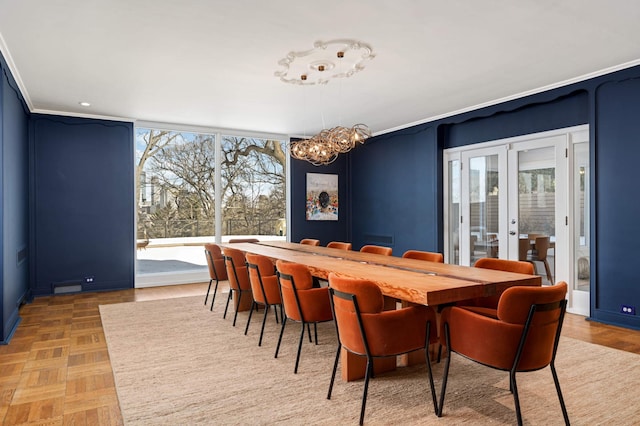 dining space with ornamental molding, a notable chandelier, and french doors