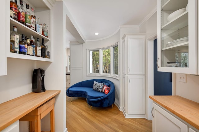 living area featuring light wood-type flooring, ornamental molding, and recessed lighting