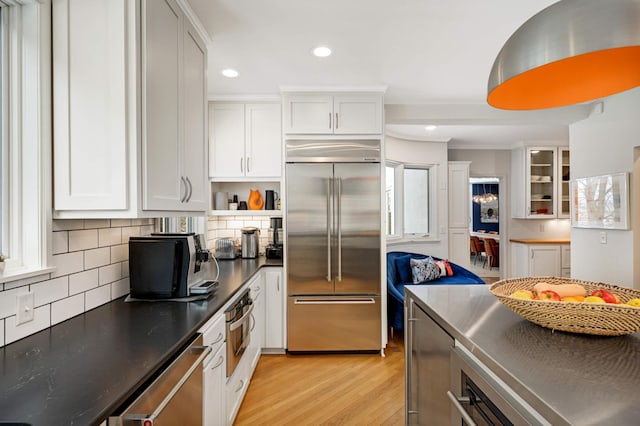 kitchen with recessed lighting, light wood-style floors, white cabinets, appliances with stainless steel finishes, and tasteful backsplash