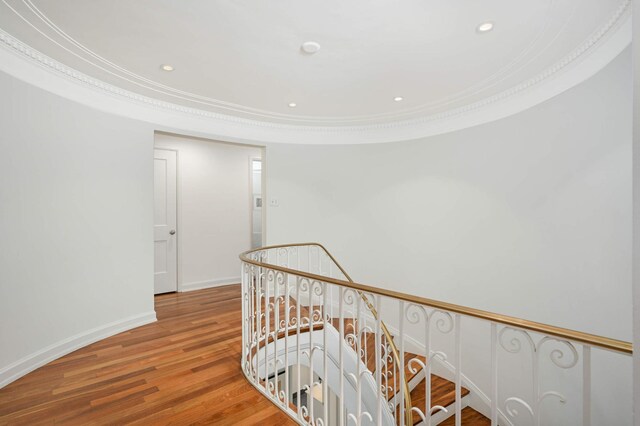 hallway with baseboards, wood finished floors, crown molding, an upstairs landing, and recessed lighting