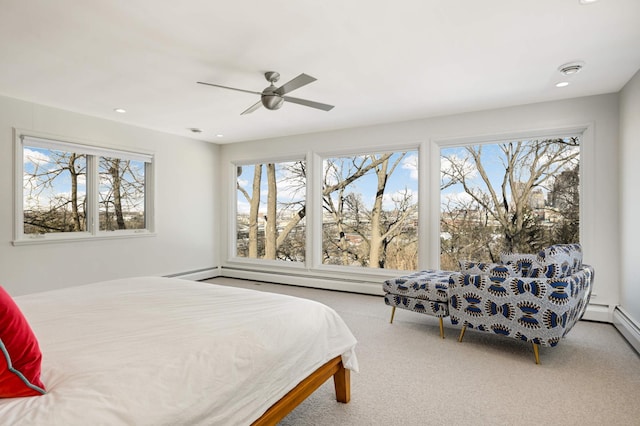 carpeted bedroom with ceiling fan, multiple windows, a baseboard heating unit, and recessed lighting