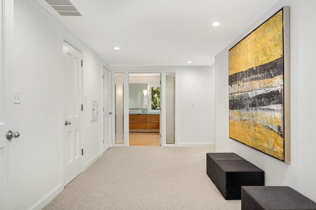 hallway with light carpet, baseboards, and recessed lighting