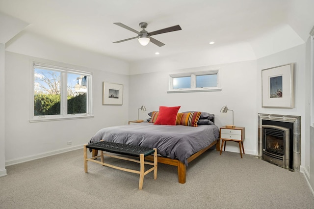 carpeted bedroom with a ceiling fan, recessed lighting, a lit fireplace, and baseboards