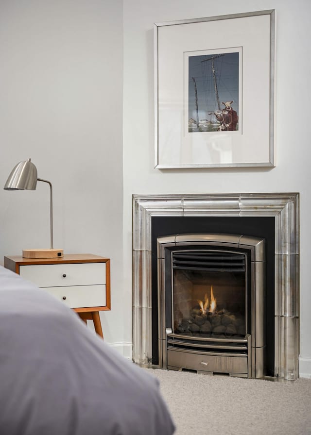 unfurnished bedroom featuring a lit fireplace