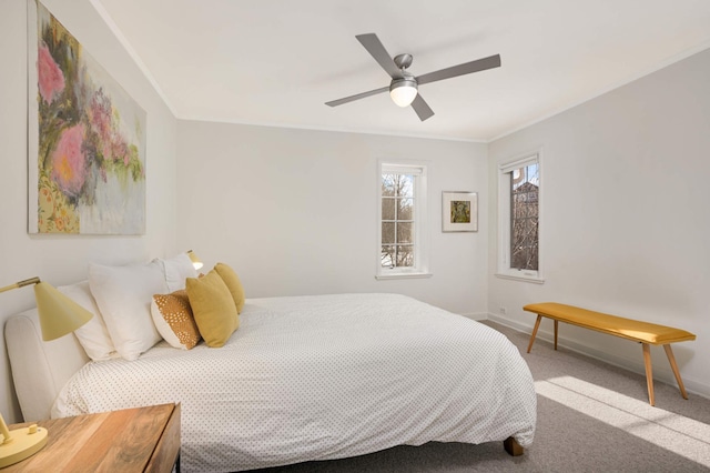 carpeted bedroom with baseboards, a ceiling fan, and ornamental molding