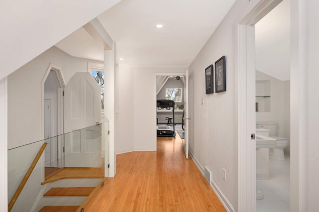 hallway featuring visible vents, baseboards, light wood-style flooring, and recessed lighting