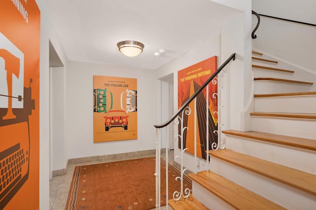 stairs featuring tile patterned flooring and baseboards