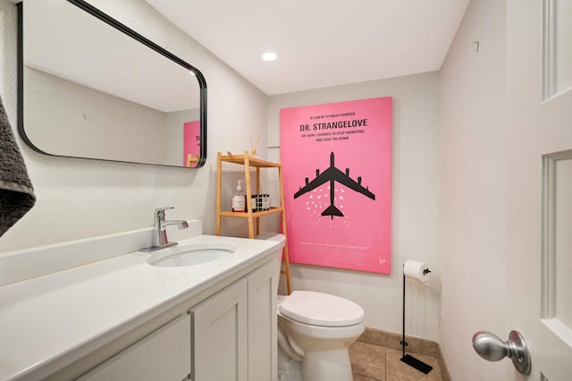 half bath featuring vanity, toilet, and tile patterned floors