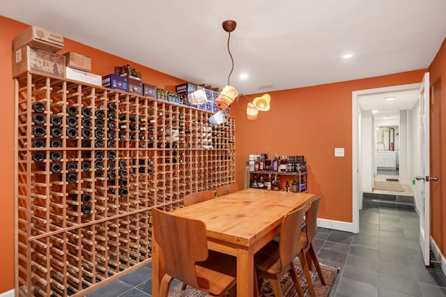 wine room featuring dark tile patterned flooring, baseboards, and recessed lighting