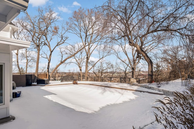 yard covered in snow featuring fence