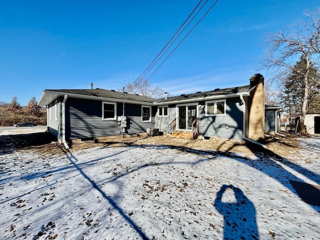 rear view of house featuring central air condition unit and a chimney