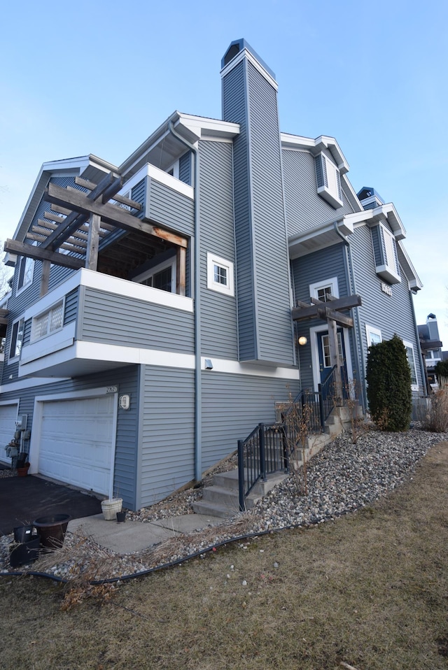 view of home's exterior featuring a chimney and an attached garage