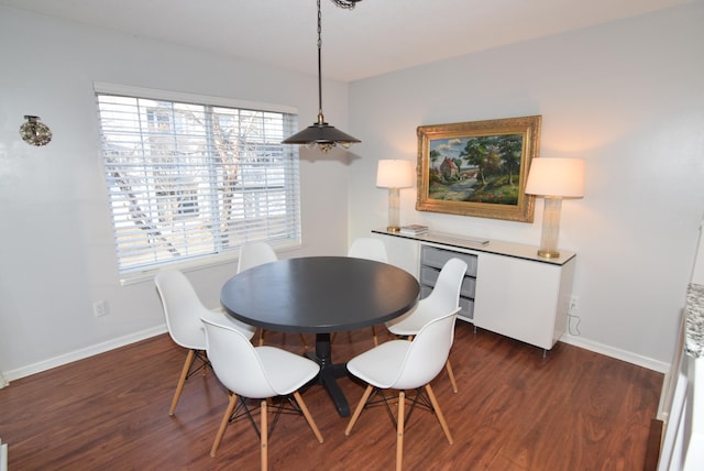 dining area with dark wood-type flooring and baseboards
