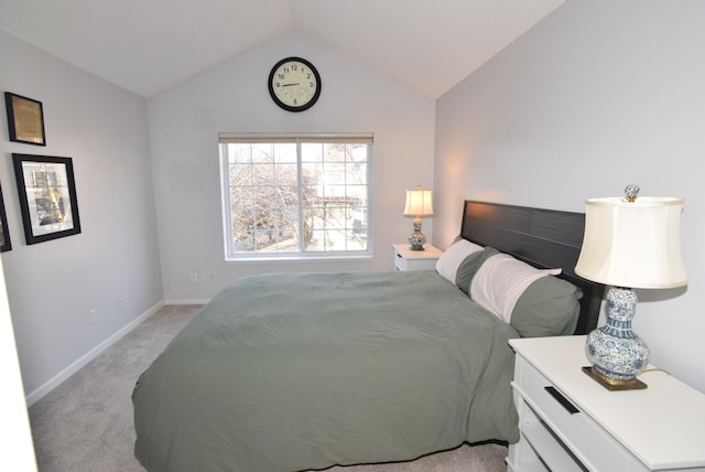 bedroom with baseboards, vaulted ceiling, and light colored carpet