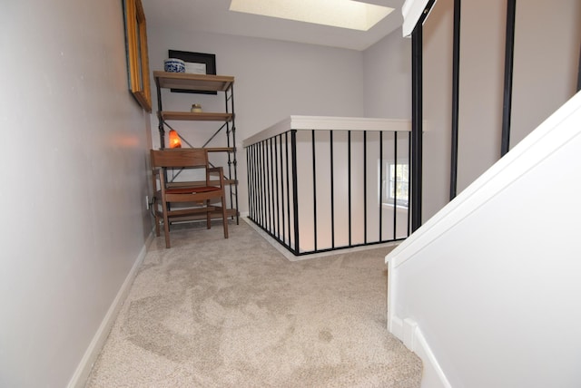 stairs with carpet floors, a skylight, and baseboards