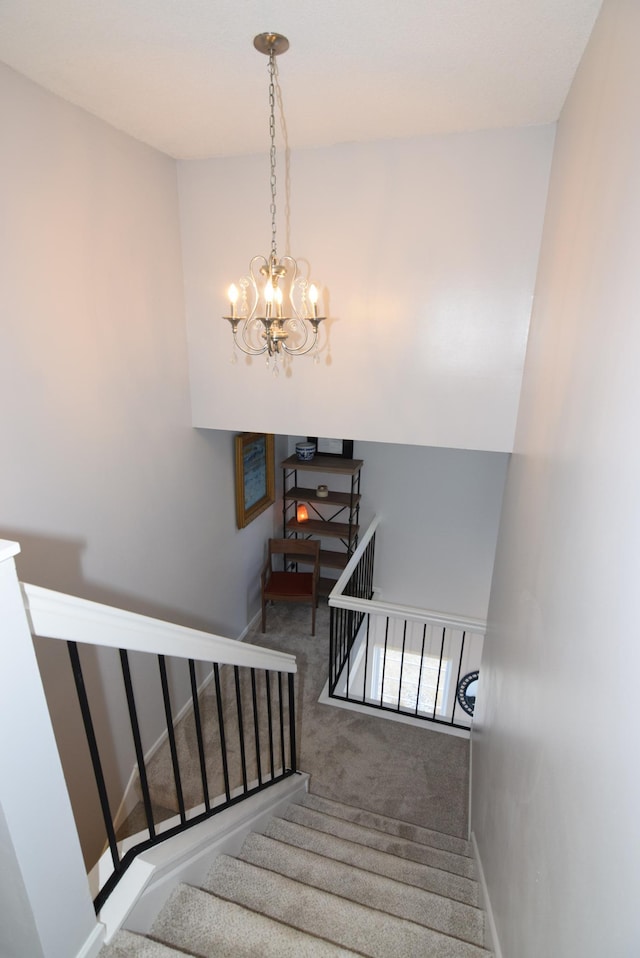 stairway featuring a notable chandelier, carpet flooring, and baseboards