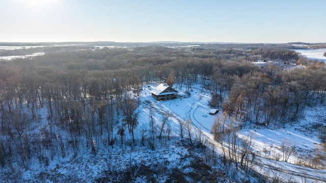 snowy aerial view featuring a wooded view