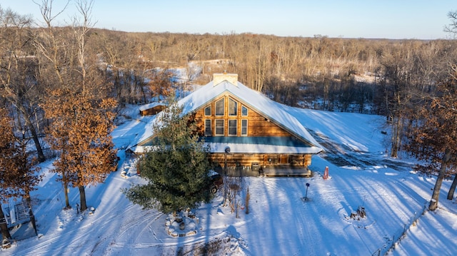 snowy aerial view with a wooded view