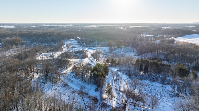 snowy aerial view featuring a forest view