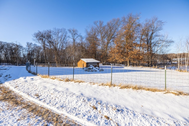 yard layered in snow featuring fence and an outdoor structure