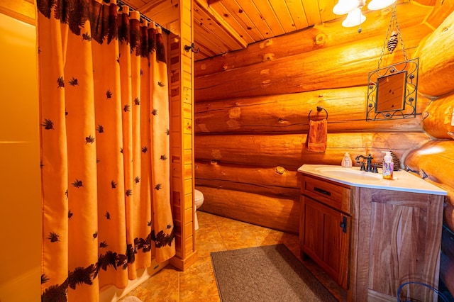 bathroom featuring rustic walls, wooden ceiling, toilet, and vanity