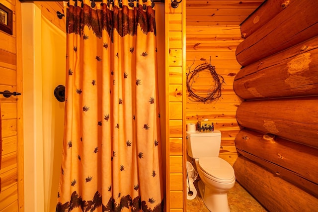 bathroom featuring toilet and log walls