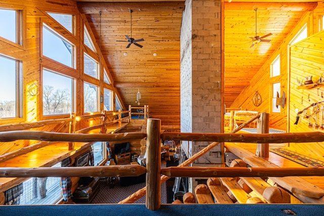 bonus room with wood ceiling, high vaulted ceiling, rustic walls, and a ceiling fan