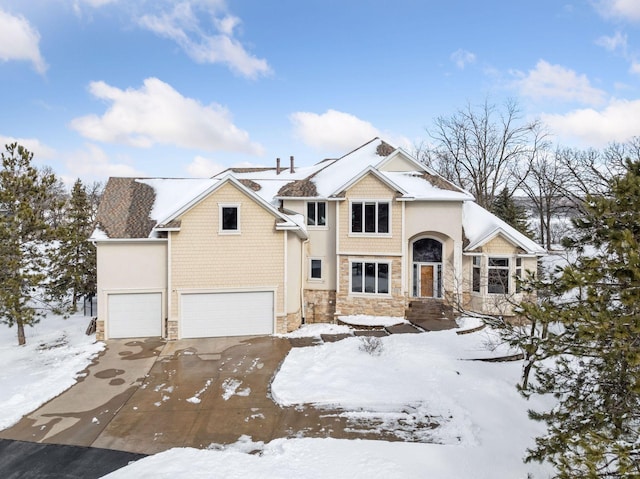 view of front of house with stone siding, an attached garage, and concrete driveway