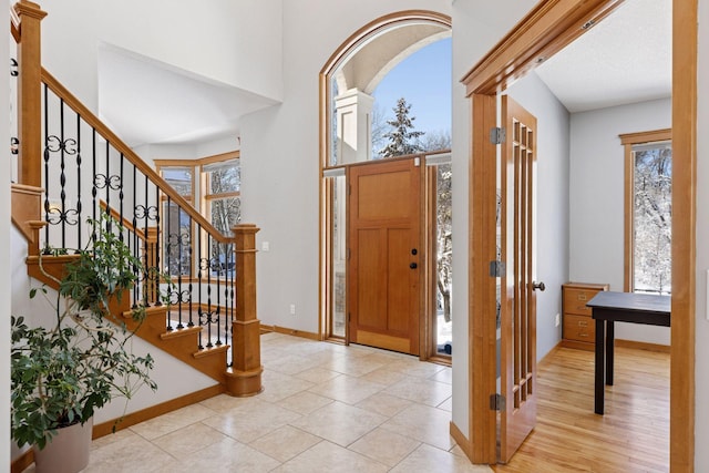 entrance foyer featuring tile patterned flooring, stairway, and baseboards