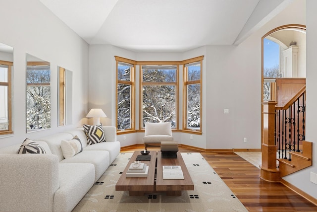 living area featuring stairway, baseboards, and wood finished floors