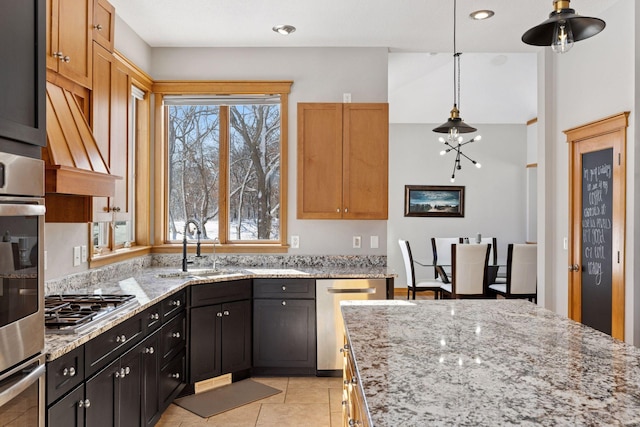 kitchen featuring hanging light fixtures, light tile patterned floors, light stone countertops, and appliances with stainless steel finishes