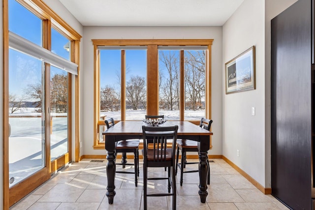 dining room featuring light tile patterned floors, baseboards, and a healthy amount of sunlight