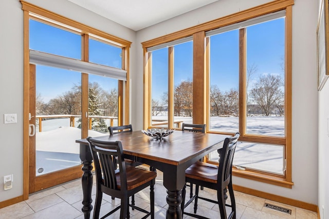 dining area featuring light tile patterned floors, visible vents, and baseboards