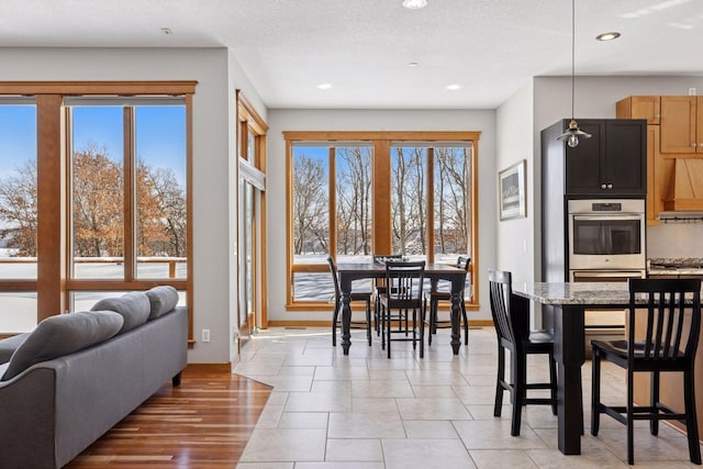 dining room with recessed lighting, baseboards, and a textured ceiling