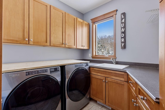 laundry area with a sink, light tile patterned floors, cabinet space, and washing machine and clothes dryer