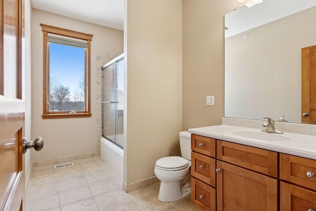 bathroom with visible vents, toilet, shower / bath combination with glass door, tile patterned flooring, and vanity