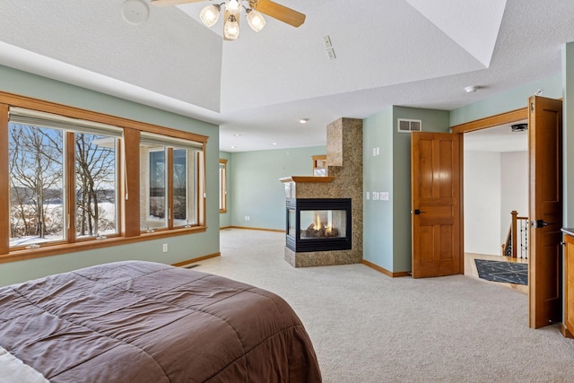 bedroom with visible vents, light colored carpet, baseboards, and vaulted ceiling