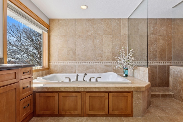 full bath featuring a garden tub, tile walls, and a walk in shower