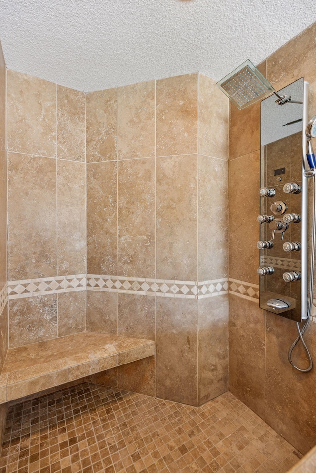 full bath featuring tiled shower and a textured ceiling