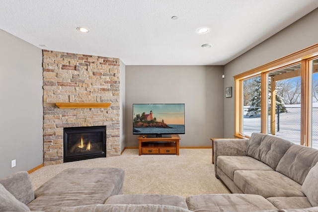 carpeted living room with recessed lighting, a fireplace, a textured ceiling, and baseboards