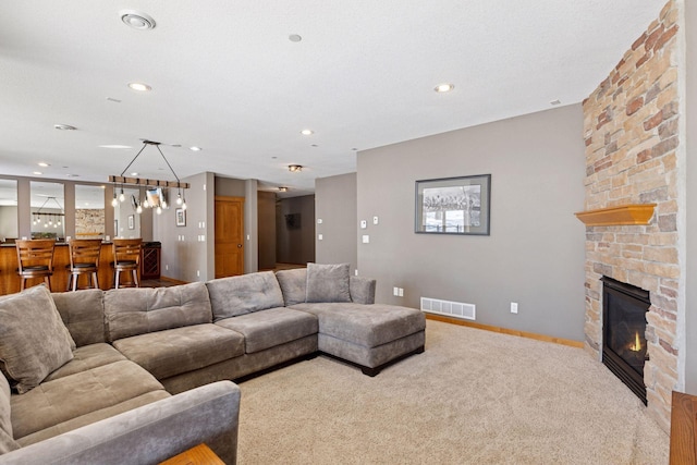 carpeted living room with visible vents, recessed lighting, baseboards, a large fireplace, and bar area