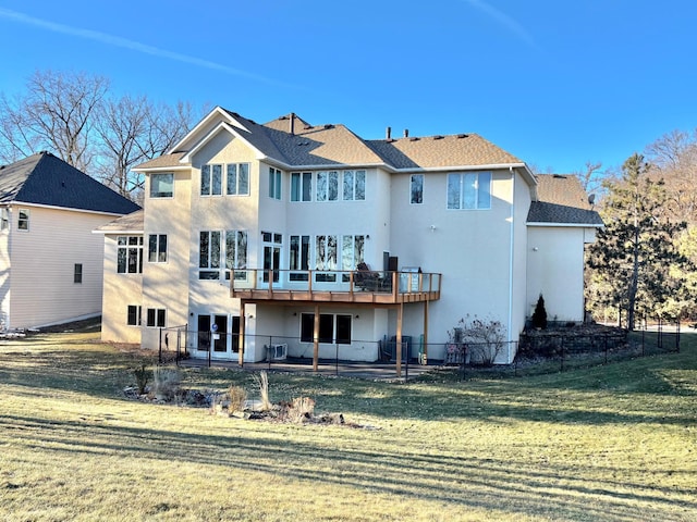 back of property with stucco siding, a lawn, a deck, and a patio area