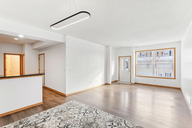 spare room featuring visible vents, baseboards, wood finished floors, and recessed lighting